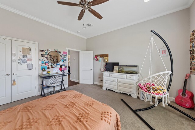 carpeted bedroom featuring visible vents, crown molding, a closet, baseboards, and a ceiling fan
