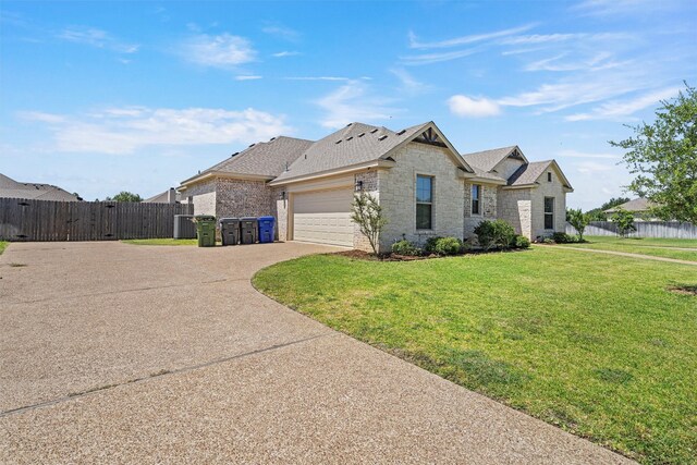 view of front of home featuring fence, a gate, driveway, and a front lawn