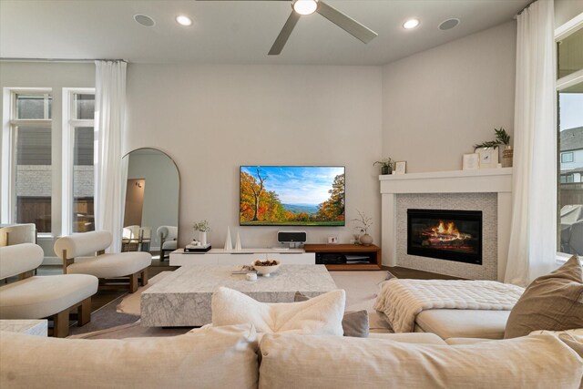 living area featuring recessed lighting, ceiling fan, a glass covered fireplace, and a healthy amount of sunlight