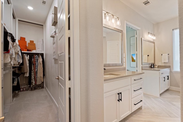3320 Alexandra Ln, Celina, TX 75009 - bathroom featuring two vanities, baseboards, a spacious closet, and recessed lighting