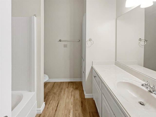 bathroom with vanity, baseboards, toilet, and wood finished floors