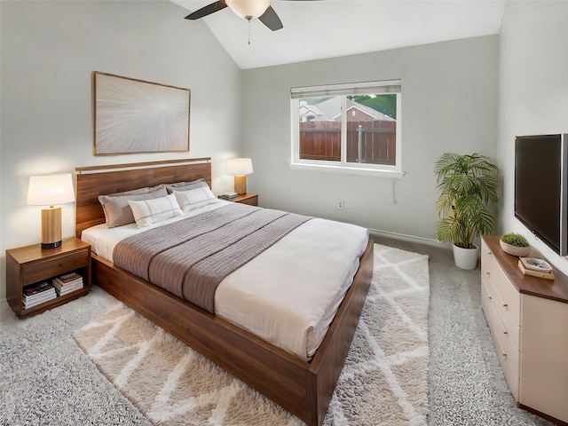 bedroom featuring a ceiling fan, baseboards, vaulted ceiling, and light carpet