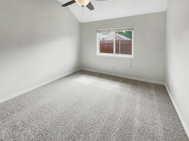 spare room featuring baseboards, ceiling fan, and vaulted ceiling