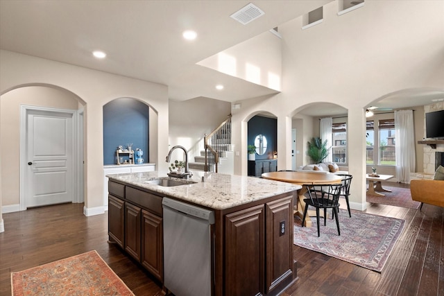kitchen featuring dark wood-style flooring, a sink, dishwasher, open floor plan, and a center island with sink