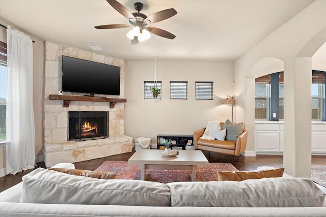living room featuring a healthy amount of sunlight, a fireplace, a ceiling fan, and visible vents