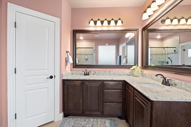bathroom featuring double vanity, a sink, and a stall shower