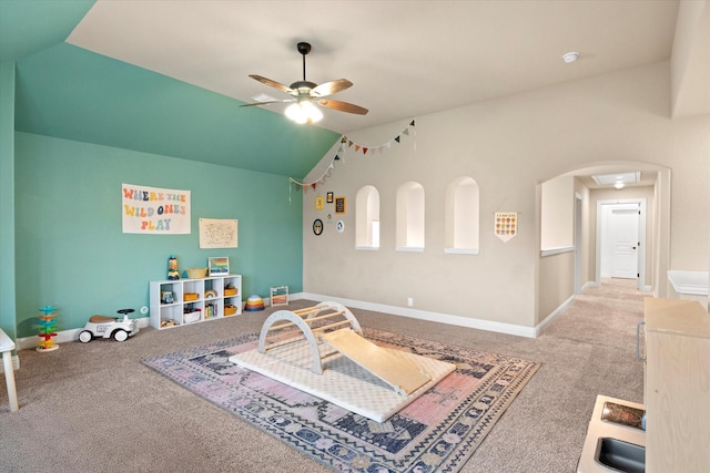 game room with a ceiling fan, arched walkways, lofted ceiling, and carpet