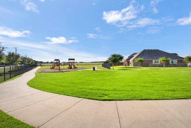 surrounding community featuring a yard, playground community, and fence