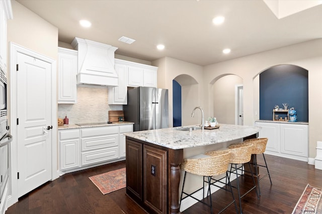 kitchen with a sink, freestanding refrigerator, custom exhaust hood, and dark wood-style floors