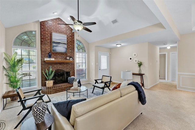 living area featuring a ceiling fan, visible vents, a fireplace, vaulted ceiling, and light carpet