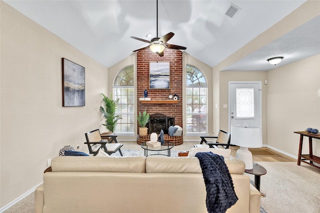 carpeted living room featuring a ceiling fan, visible vents, a brick fireplace, baseboards, and lofted ceiling