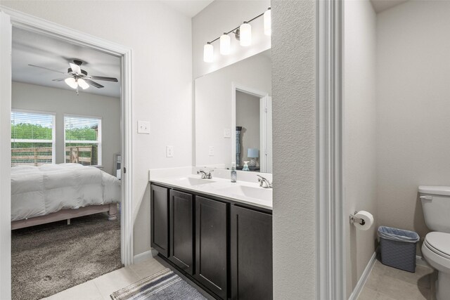 bathroom featuring tile patterned flooring, toilet, ceiling fan, a sink, and ensuite bath