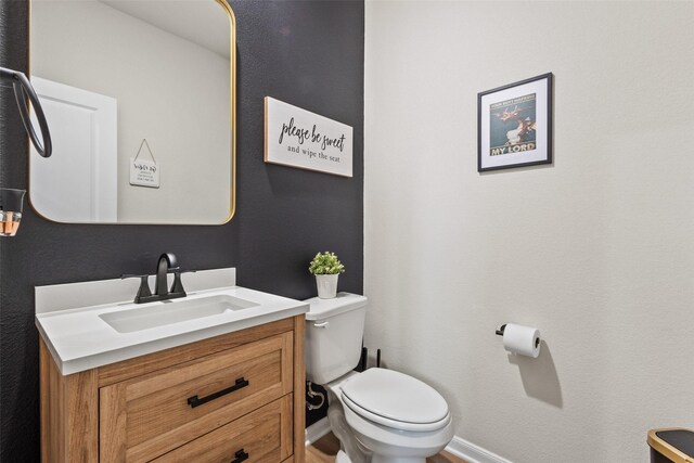 bathroom with vanity, baseboards, and toilet