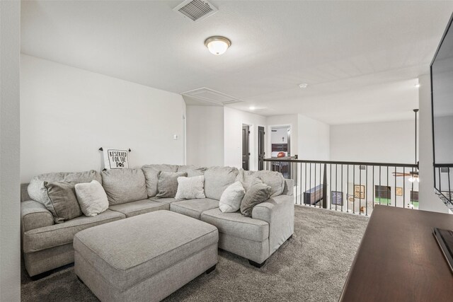 carpeted living room with visible vents and attic access