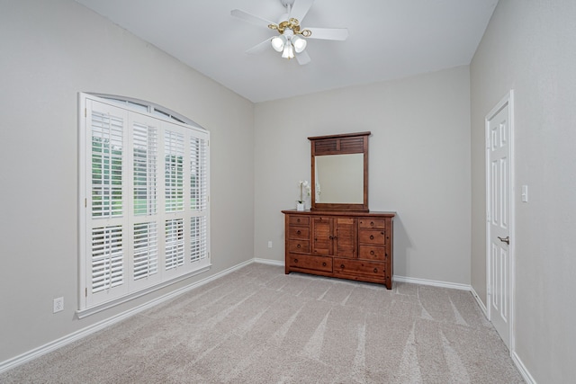bedroom featuring light colored carpet, a ceiling fan, baseboards, ensuite bathroom, and visible vents