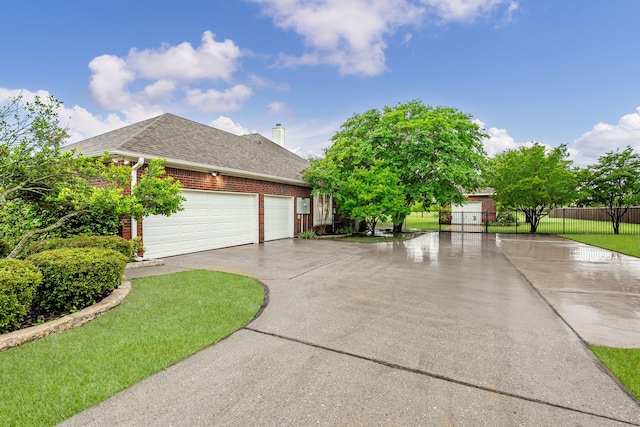 view of front of house featuring fence, a shingled roof, an attached garage, brick siding, and driveway