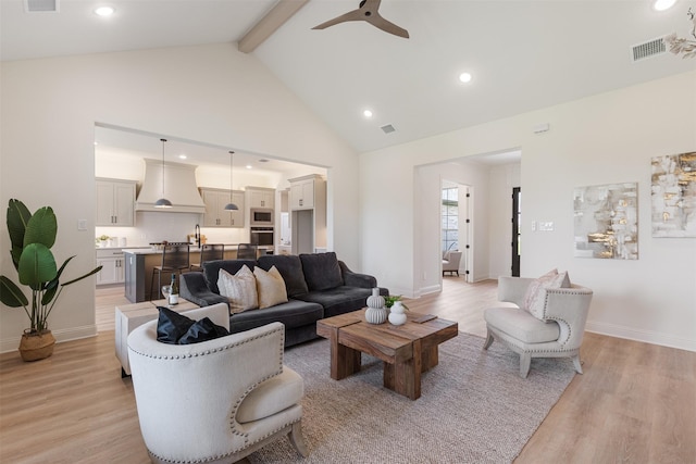 living room with visible vents, light wood-style floors, ceiling fan, and beam ceiling