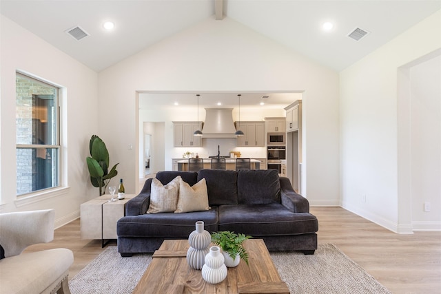 living room featuring recessed lighting, visible vents, lofted ceiling with beams, and light wood-style floors