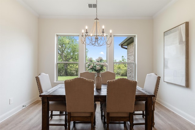 dining space featuring an inviting chandelier, baseboards, light wood-type flooring, and visible vents