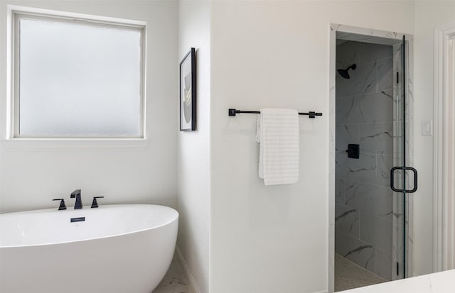 bathroom with baseboards, a sink, a marble finish shower, and a freestanding tub