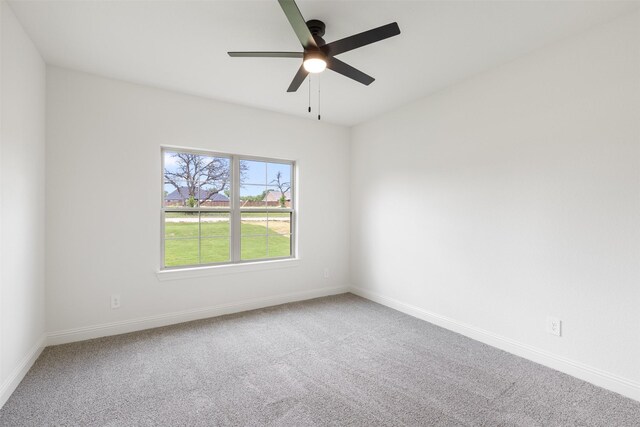 spare room with carpet flooring, a ceiling fan, and baseboards