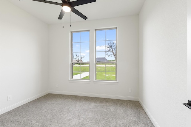 unfurnished room with carpet flooring, a ceiling fan, and a wealth of natural light