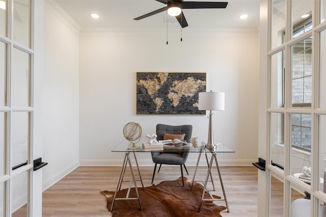 office space with a ceiling fan, baseboards, ornamental molding, and light wood finished floors