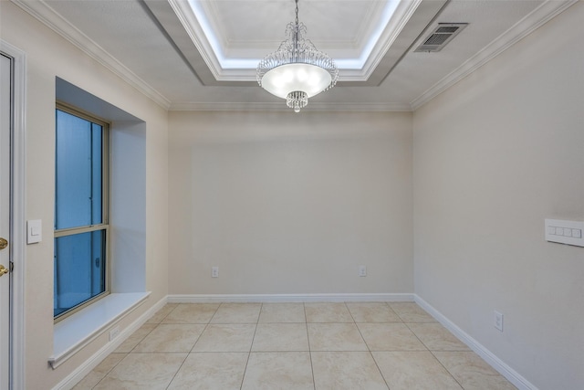 unfurnished room with a raised ceiling, ornamental molding, a notable chandelier, and visible vents