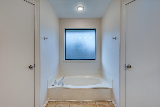 bathroom featuring a garden tub, baseboards, and tile patterned floors