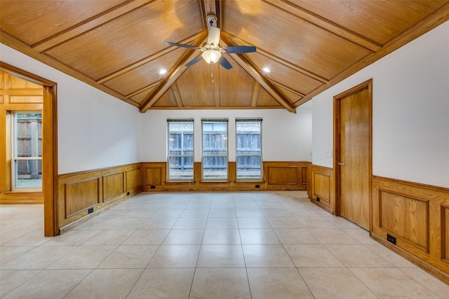 empty room with a ceiling fan, wooden ceiling, and a wainscoted wall
