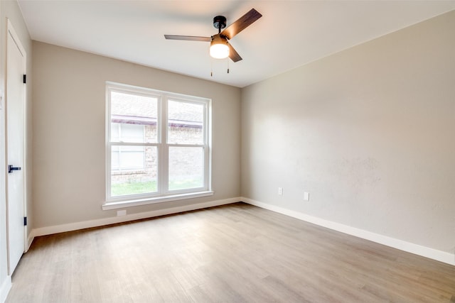 spare room with light wood-style floors, baseboards, and a ceiling fan