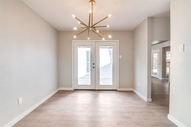 entryway featuring an inviting chandelier, baseboards, french doors, and light wood-type flooring