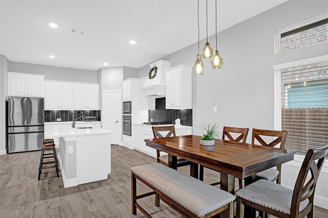 dining space with light wood-style flooring and recessed lighting