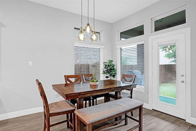 dining area featuring light wood-style flooring and baseboards