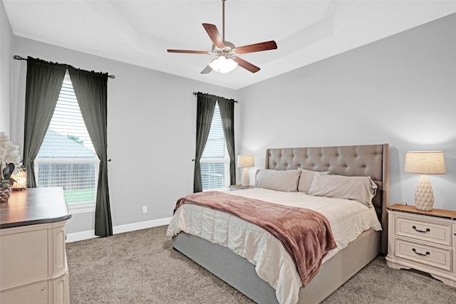 bedroom with light carpet, multiple windows, baseboards, and a ceiling fan