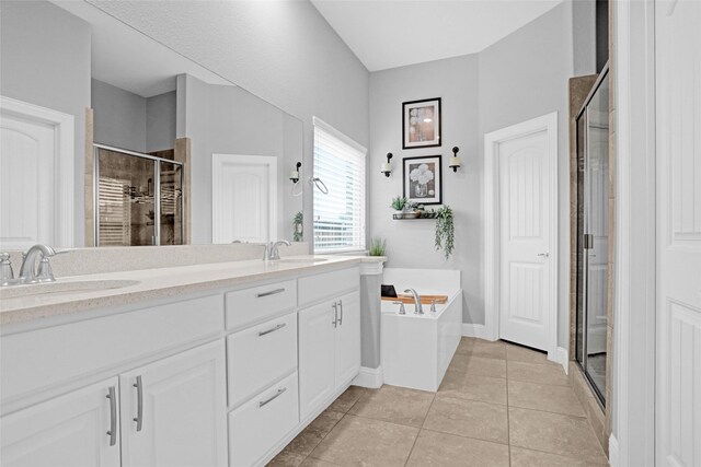 full bathroom with a stall shower, tile patterned flooring, double vanity, a bath, and baseboards