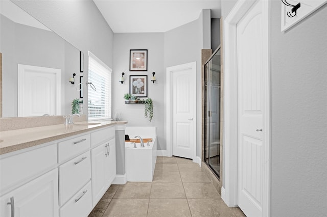 bathroom with a shower stall, double vanity, a garden tub, and tile patterned flooring