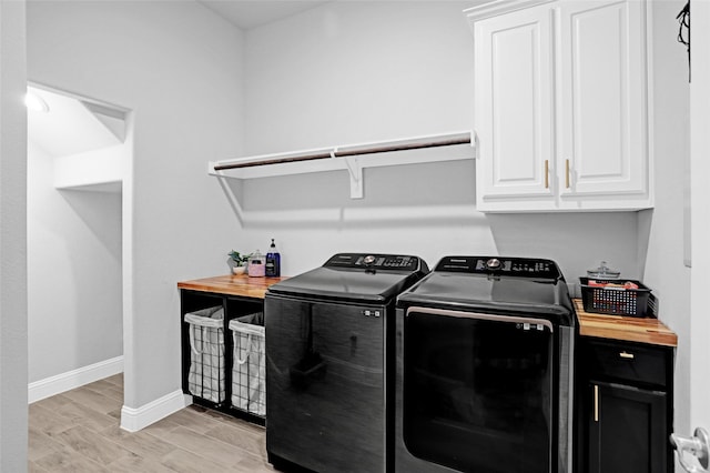 laundry room with washing machine and dryer, cabinet space, light wood finished floors, and baseboards
