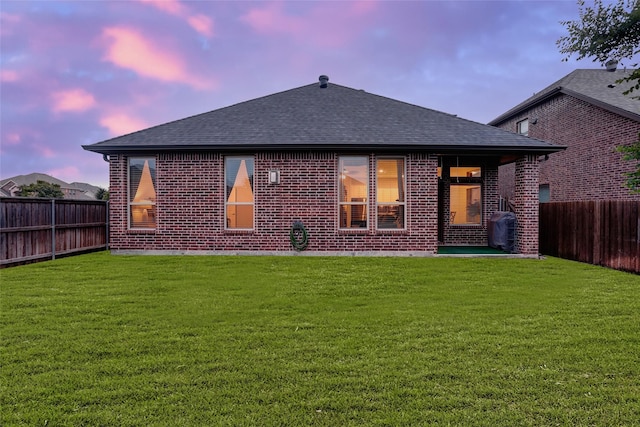 back of house featuring roof with shingles and brick siding