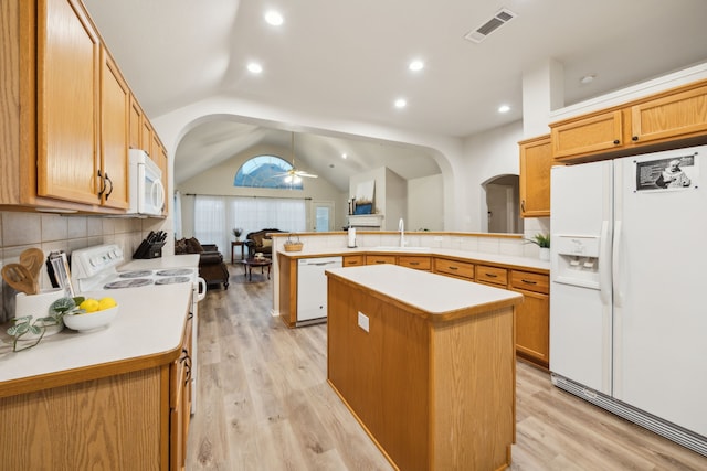 kitchen featuring visible vents, a peninsula, white appliances, open floor plan, and arched walkways
