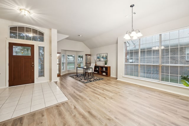 entryway with visible vents, a chandelier, baseboards, wood finished floors, and vaulted ceiling