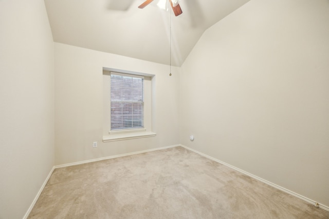 unfurnished room featuring baseboards, ceiling fan, vaulted ceiling, and light carpet