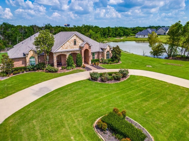 261 Chisholm Ranch Dr, Rockwall, TX 75032 - view of front of home with a front lawn, brick siding, stone siding, a water view, and curved driveway