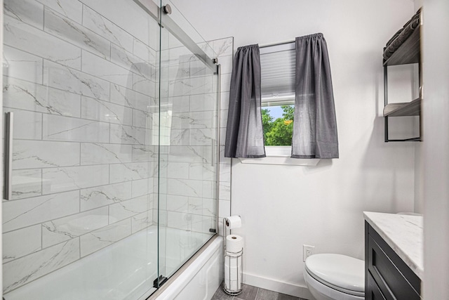672 Harbor Dr, Azle, TX 76020 - full bath with vanity, toilet, bath / shower combo with glass door, baseboards, and wood finished floors