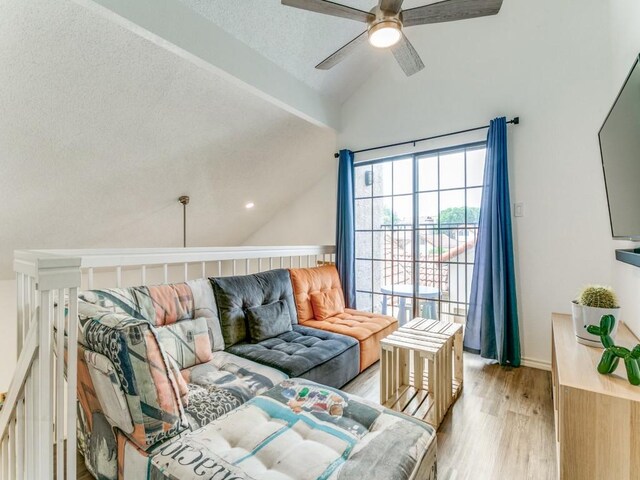 interior space with ceiling fan, light wood-type flooring, a textured ceiling, and lofted ceiling