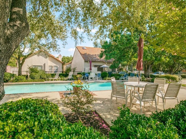community pool featuring a patio area and fence
