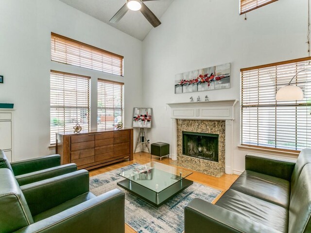 living room featuring a ceiling fan, high vaulted ceiling, a wealth of natural light, and wood finished floors