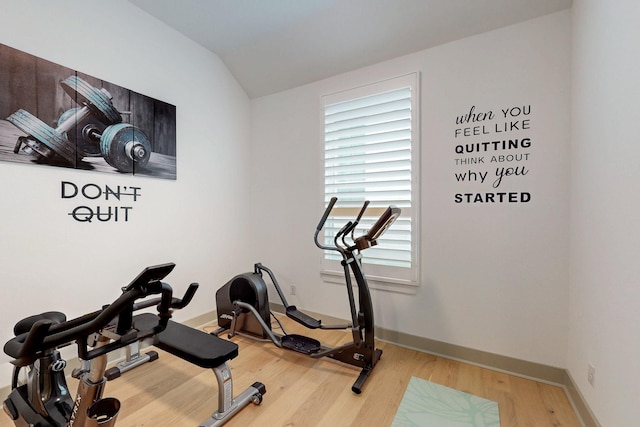 workout room with wood finished floors, baseboards, and lofted ceiling