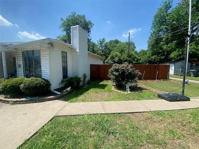 10721 Hermosa Dr, Dallas, TX 75218 - view of home's exterior with fence, a chimney, and a lawn