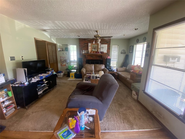 10721 Hermosa Dr, Dallas, TX 75218 - living room with a healthy amount of sunlight, ceiling fan, a textured ceiling, a brick fireplace, and carpet flooring